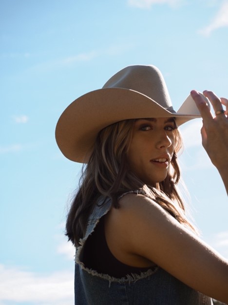 One female with hand touching hat